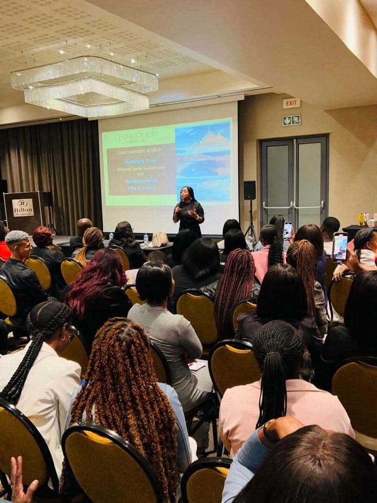 A full audience watching a speaker present at a conference